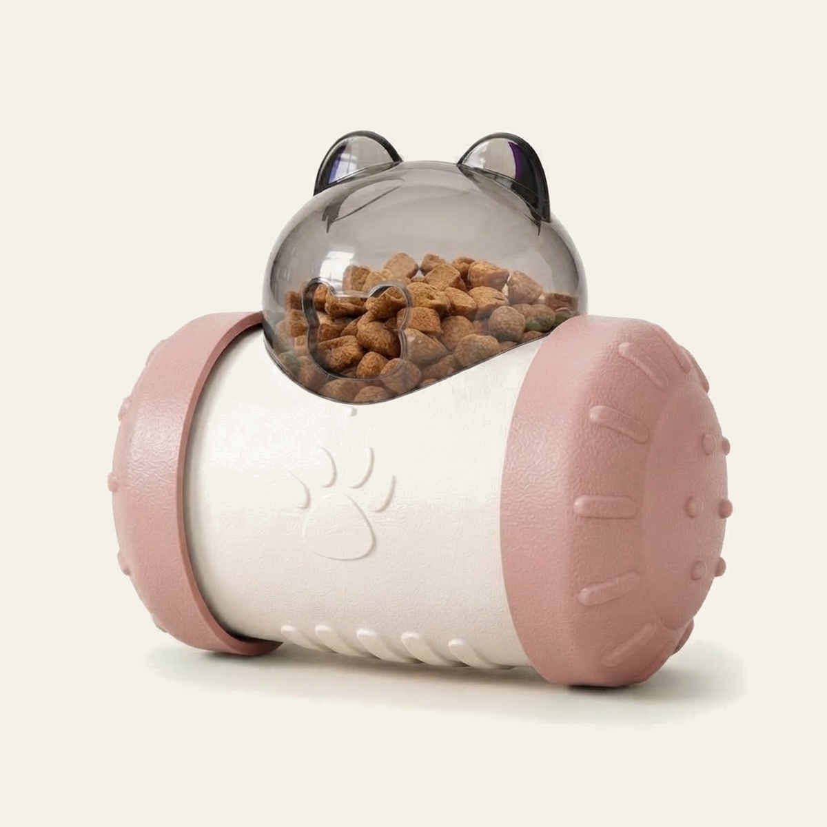 Distributeur de croquettes culbuto pour chat coloris rose : corps blanc, flasques roses et dôme transparent à oreilles rempli de croquettes