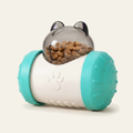 Distributeur de croquettes culbuto pour chat coloris turquoise : corps blanc, flasques turquoise et dôme transparent à oreilles rempli de croquettes